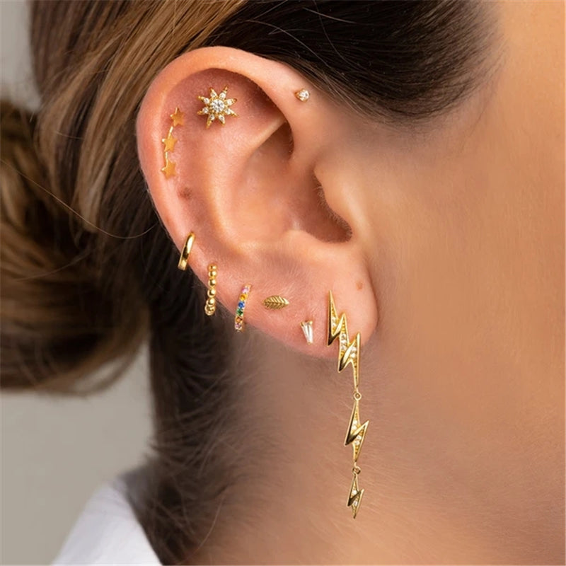 piercing oreille pour l'helix représentant un soleil doré avec des zircons porté sur une femme