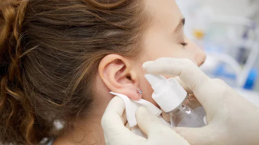 femme désinfectant un piercing à l'oreille