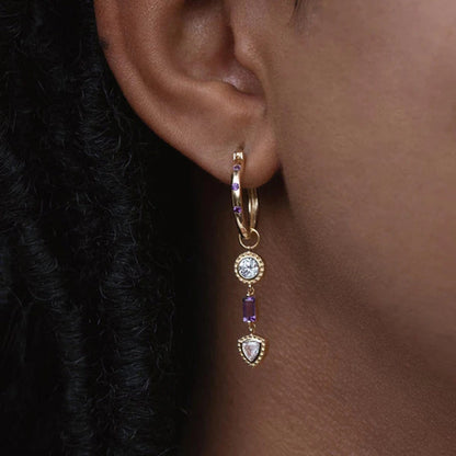 Contraste éblouissant entre zircons violets et blancs sur boucles d'oreilles