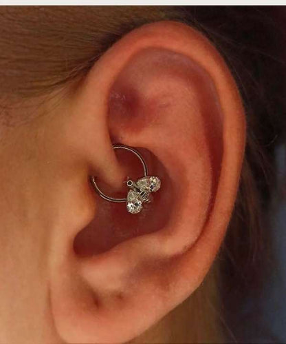 "Piercing Anneau Abeille argenté porté sur une oreille féminine."