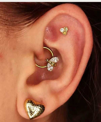 "Piercing Daith Anneau Abeille en Titane doré porté sur une oreille féminine."