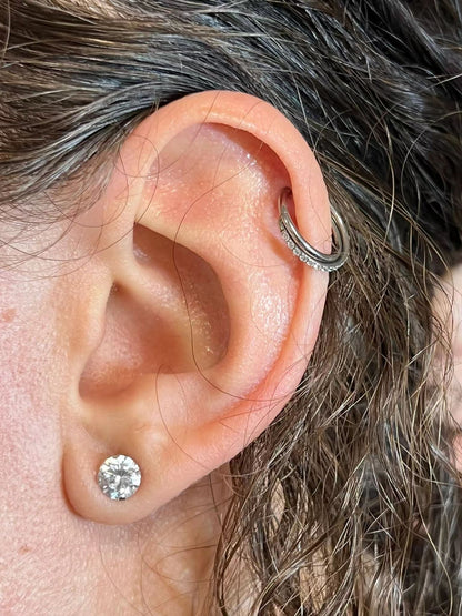 "Piercing d'Oreille Anneau Croisé porté sur une oreille féminine."