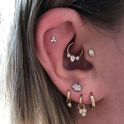 Piercing Daith Anneau et Zircons porté sur une oreille.