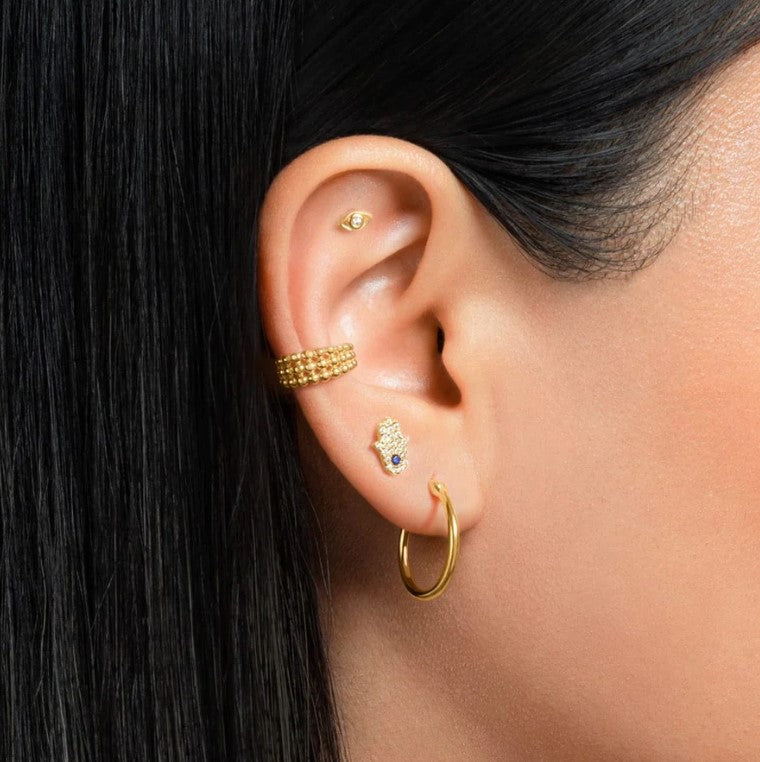 "Femme portant le Piercing Helix Oriental en finition dorée"